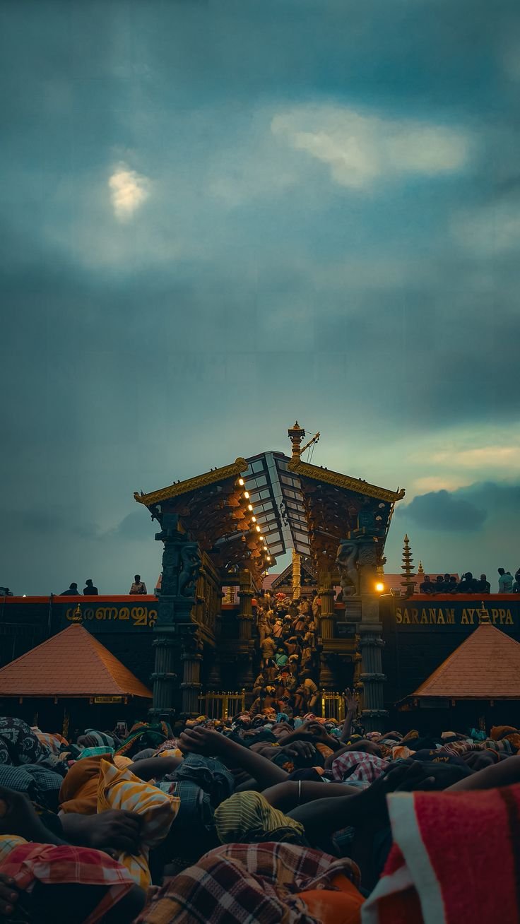 Sabarimala temple entrance at dusk with pilgrims